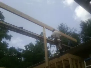 Carpenter setting a ridge beam over a new addition frame — Ice Dam Removal by Roofing Brothers in Kings Park