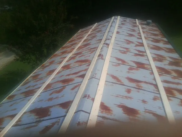Rusted metal roof panels with new wood purlins before replacement — Storm Damage Roof Repair in Kings Park by Roofing Brothers