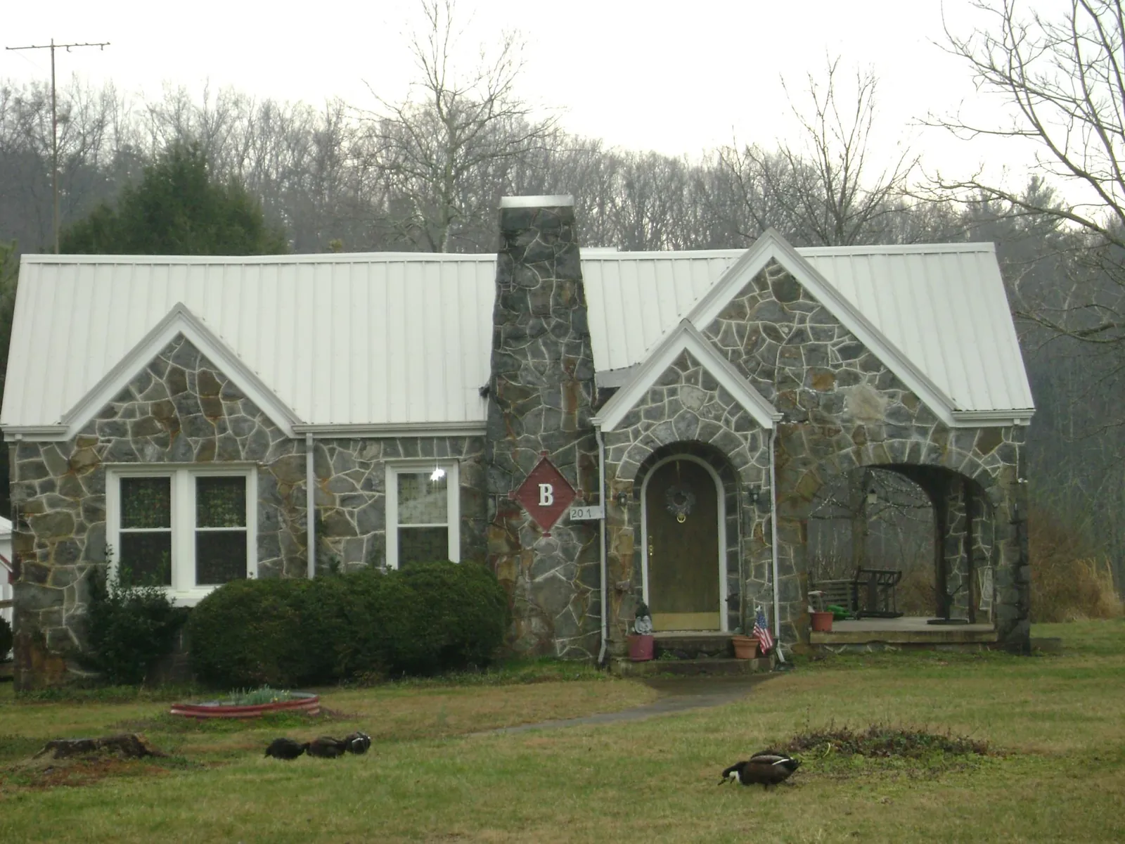 White metal roof on a stone cottage with steep gables in Kings Park