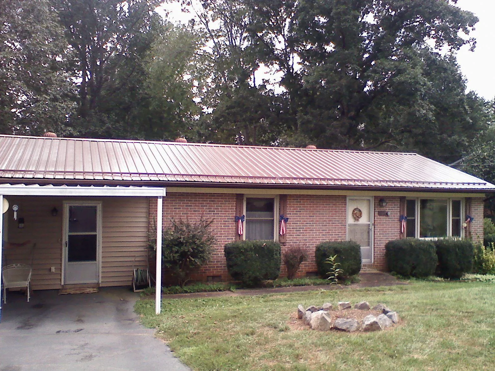 Bronze metal roof and carport on a brick ranch home — Roof Repair work by our crew in Kings Park